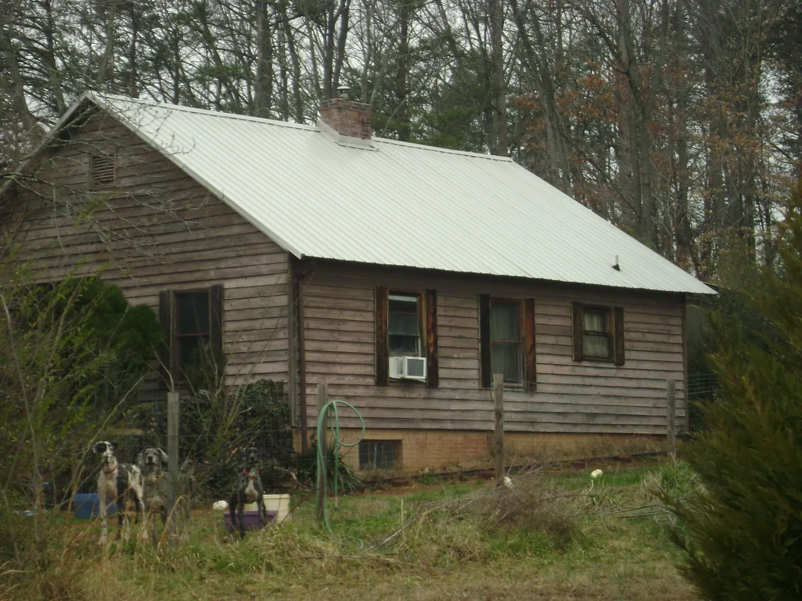 White metal roof on an old wood sided farmhouse, from a Metal Roof Installation job in Red Oak